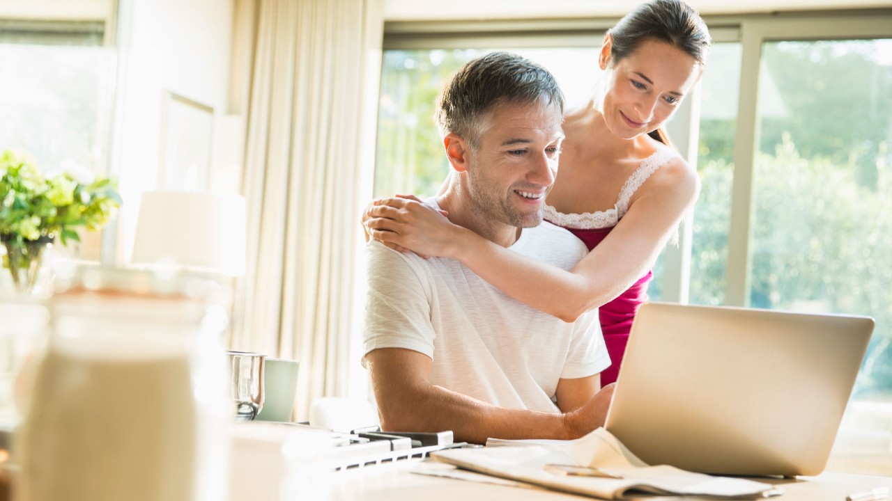 couple holding checking laptop